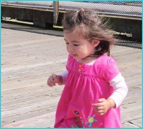 little girls outdoors on boardwalk wearing pink dress